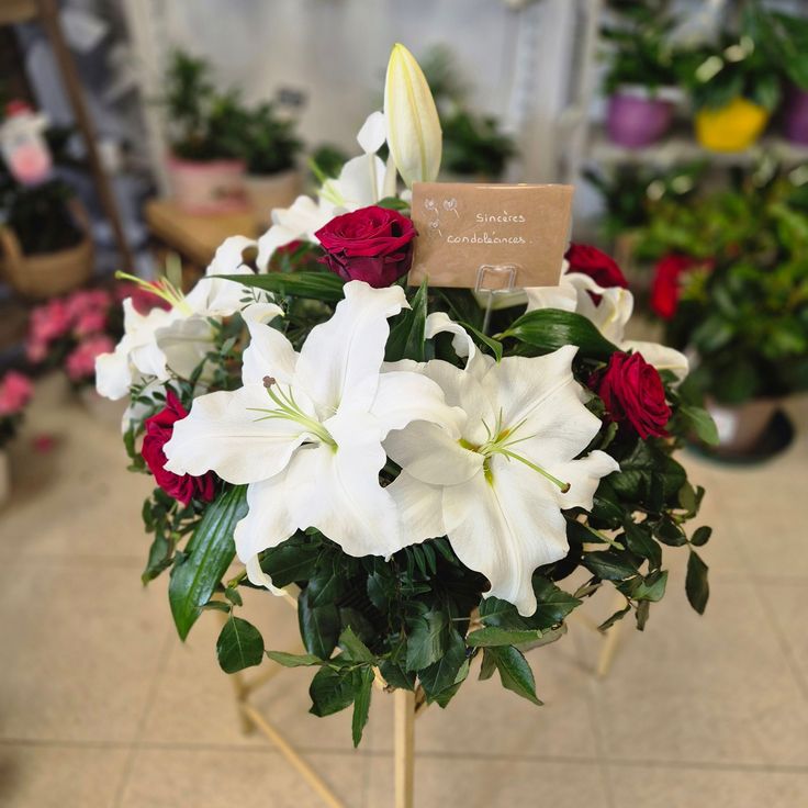 This may contain: a bouquet of white and red flowers in a vase